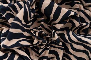 Close-up of beige and black zebra print fabric with soft folds and abstract pattern, selective focus photo