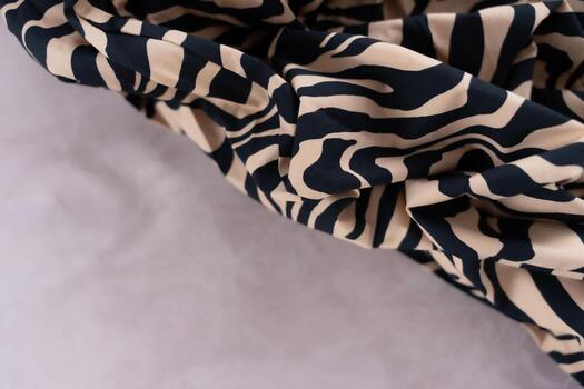 Zebra obliquely print fabric with beige and black pattern on soft background, close-up, copy space photo
