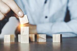 Business men are stacking wooden blocks stacking as step stair on table. New normal Business development Decide and choose, Business concept for growth success process, Vintage tone.Copy space photo