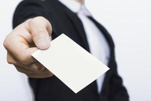 Suit clad executive offering blank card mockup symbolizing business introduction future collaboration. photo