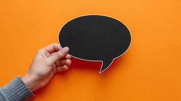 Blank Speech Bubble in Hand on Orange Background for Mockups photo