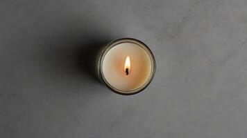 Top-Down View of Lit Candle in Glass Jar on Gray Surface, Serenity photo