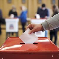 A Person Casts Their Vote at a Polling Station in a Democracy photo