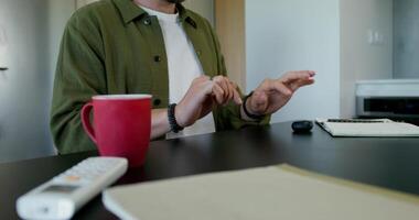 A man in a virtual reality headset typing on a virtual keyboard sitting at a table at home. Daylight - virtual photo