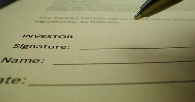 The man puts his signature on the document on behalf of the investor, close-up of his signature, an unrecognizable person - behalf photo