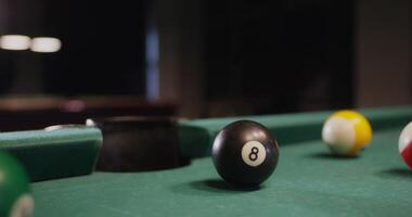 A billiard ball flies into the hole, close-up. No people in the , just a pool table, vertical photo