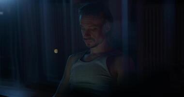 A man uses a laptop while sitting on the couch at night. photo