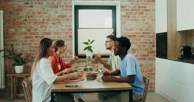A group of young people talking while having lunch together at home during vacation photo