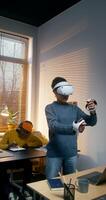 A young woman in a virtual reality headset uses a joystick standing in an office. A man draws on a graphics tablet with a stylus sitting at a table - tablet photo