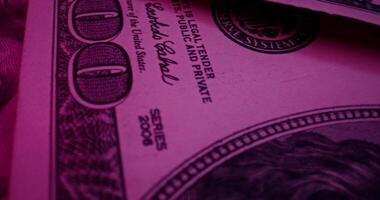 Hundred dollar bills are scattered on the table. An overview of the details of paper money in ultraviolet light - overview photo