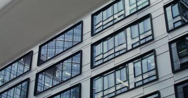 Facade of an office building with large panoramic windows. Business Quarter, no people on . The gray building of the business center. in 4k, red komodo - building photo