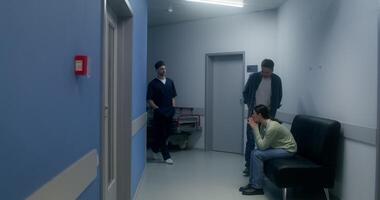 The doctor informs the relatives of the disappointing result of the operation, they cry, standing hugging in the hospital corridor - relatives photo