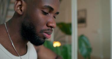 A man eats pancakes and drinks juice sitting at a table at home, close-up of his face photo