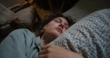 A woman is crying and hugging a pillow lying in bed at home. The mascara is smeared under the eyes - pillow photo