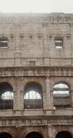 Close-up of the middle part of the Colosseum with arches and vaults on a sunny clear day, vertical . Italy Rome. in 4k, red komodo photo