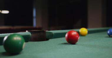 A billiard ball flies into the hole, close-up. No people in the , just a pool table, vertical - vertical photo