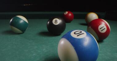 Multi-colored billiard balls in a chaotic manner lie on the billiard table, slow shooting without moving objects, without people in the frame - shooting photo