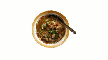 Top view of a traditional Indonesian beef soup, Soto Kwali, served in a vintage enamel bowl with rich broth, bean sprouts, herbs, and tender beef chunks. video