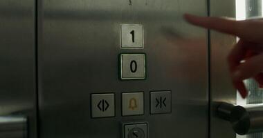 A woman presses the floor selection button in an elevator, close-up of her hand, an unrecognizable person - button photo