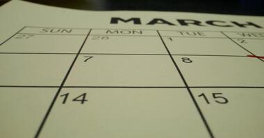 A schedule table with days of the week and numbers. One of the dates is crossed out with a red cross. Close-up - schedule photo