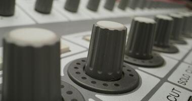 A man controls a mixing console while recording audio in the studio. Close-up of his hand, an unrecognizable person - console photo