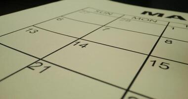 The hand circles the number in the schedule table with a red marker. Close-up, unrecognizable person photo