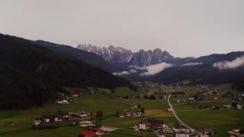 Dramatic drone view of a mountain valley with a village in a lowland with low hanging clouds covering the mountain tops. Austria, Alps filming at dusk - valley photo