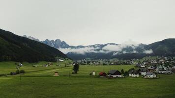 The picturesque nature of Austria from a bird's eye view. View of the village, located in a lowland between high mountains, covered with white clouds. photo