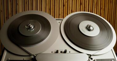 Sound recording on a tape recorder in a recording studio. Fast movement of the magnetic tape, close-up - movement photo