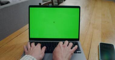 Close-up of a woman's hands while she typing on a laptop with a green screen. Front view of the screen. Copy space, mockup - mockup photo