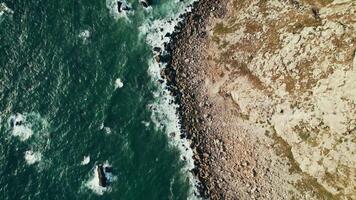 Top view of the sea waves washing the pebble beach. Drone on a summer day - summer photo