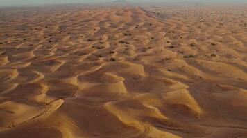 A bird's-eye view from a drone of sand dunes with traces of cars engaged in off-road driving photo
