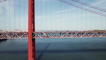 Drone view of the red suspension bridge over the river. The drone flies parallel to the bridge photo