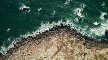 Top view of the sea waves washing the pebble beach. Drone on a summer day photo