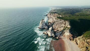 Bird's-eye view of the sea coastline with a sandy beach and stone cliffs - cliffs photo
