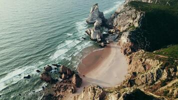 Bird's-eye view of the sea coastline with a sandy beach and stone cliffs photo