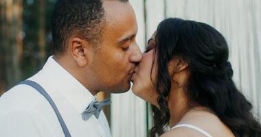 The bride and groom kiss at the wedding standing in front of the altar. Wedding in the forest photo