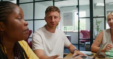 A group of young people are smiling and talking while sitting in an office meeting. Business planning, startup - sitting photo
