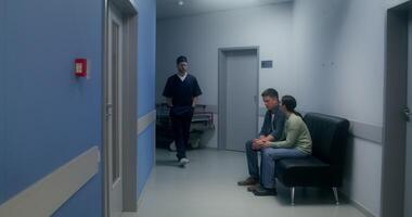 The doctor informs the relatives of the disappointing result of the operation, they cry, standing hugging in the hospital corridor - disappointing photo