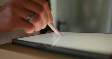 The man signs with a stylus on the tablet confirming receipt of the parcel. close-up of his hands, an unrecognizable person - confirming photo