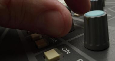 A man controls a mixing console while recording audio in the studio. Close-up of his hand, an unrecognizable person - recording photo