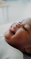 Close-up of a smiling face of an African-American child while playing with his mother lying on the couch at home photo