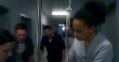 Medical staff and relatives of the victim are running down the hospital corridor carrying the patient on a gurney photo