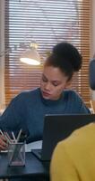 A man and a woman use laptops working at desks in the office. A man in a hat and headphones is chatting on chat and playing with a baseball - headphones photo