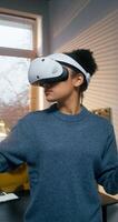 A young woman in a virtual reality headset uses a joystick standing in an office. A man draws on a graphics tablet with a stylus sitting at a table - headset photo