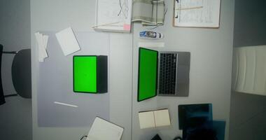 A laptop and a tablet with green screens. View from above photo