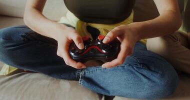 Mom and son playing games using joysticks sitting on the couch, close-up of hands, no faces photo