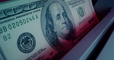 The calculating machine counts a stack of dollar bills, close-up - counts photo