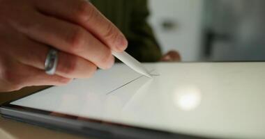 The man signs with a stylus on the tablet confirming receipt of the parcel. close-up of his hands, an unrecognizable person - receipt photo