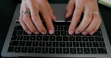 A man typing on a laptop keyboard sitting at his desk. Close-up of his hands, an unrecognizable person. Daylight - keyboard photo